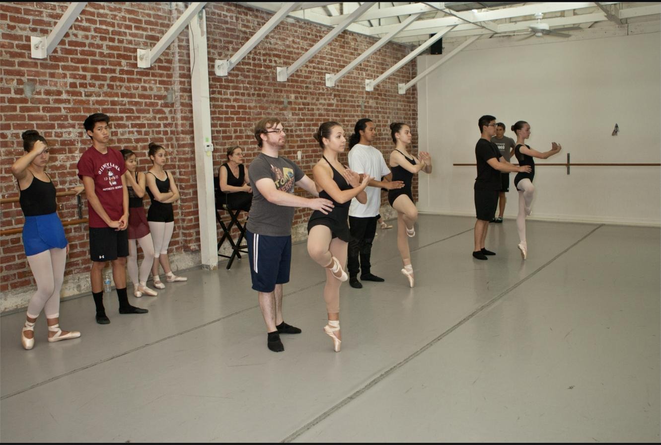 Students and instructors in an upper division ballet class at the barre